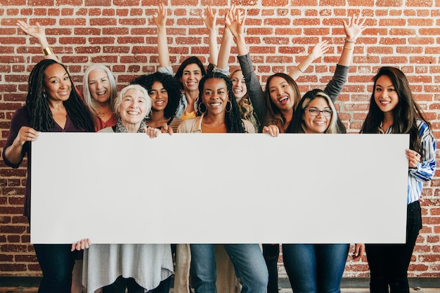 Groupe de femmes diverses montrant une maquette de bannière vierge