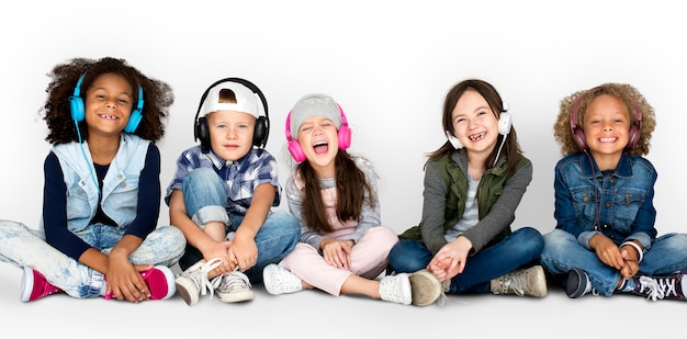 Grupo de crianças Studio sorrindo usando fones de ouvido e roupas de inverno