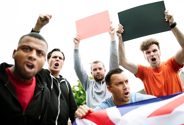 Gruppe wütende männer, die eine britische flagge und leere bretter während eines protests schreien zeigen