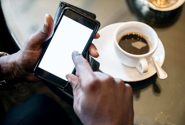 Hände, die an Mobile im Café arbeiten