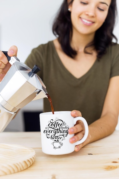 PSD una hermosa mujer joven bebiendo café en casa.