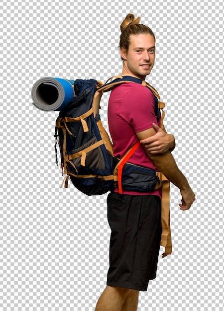 hiker man with mountain backpacker looking over the shoulder with a smile