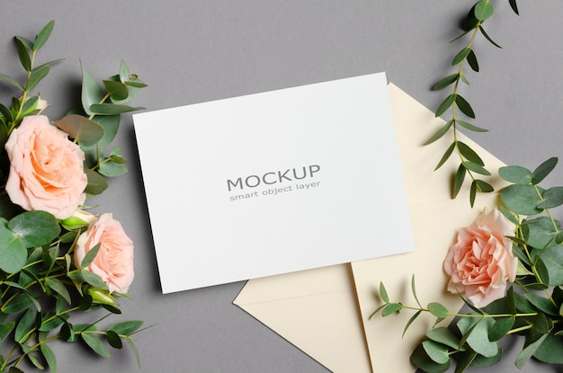 Hochzeitseinladungskarte mockup mit umschlag frischen eukalyptus- und rosenblumen