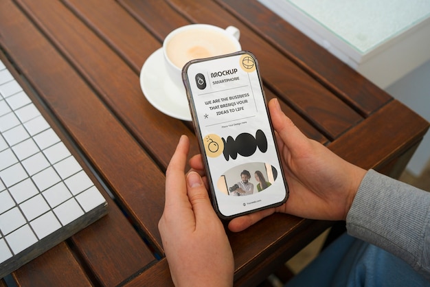 Hohe Winkelhände mit Smartphone und Kaffee