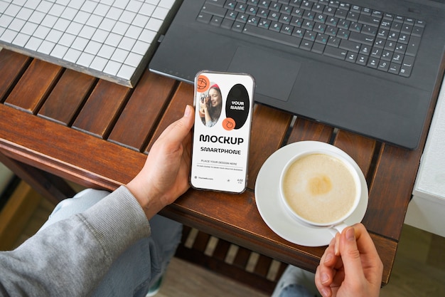Hohe Winkelhände mit Smartphone und Kaffee