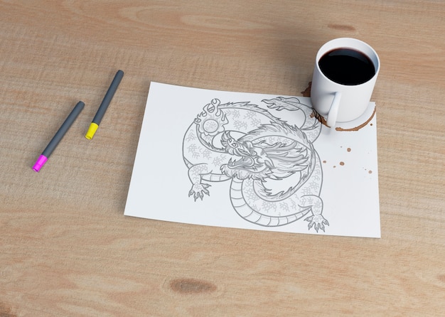 Hoja con dibujo y taza de café al lado