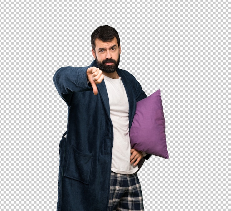 PSD hombre con barba en pijama mostrando el pulgar hacia abajo con expresión negativa