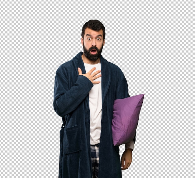 Hombre con barba en pijama sorprendido y sorprendido mientras mira a la derecha