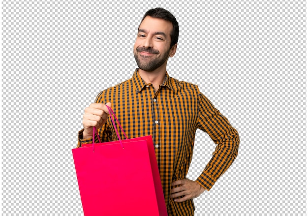 Hombre con bolsas de compras posando con los brazos en la cadera y sonriendo