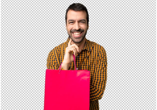 Hombre con bolsas de compras sonriendo con una dulce expresión.