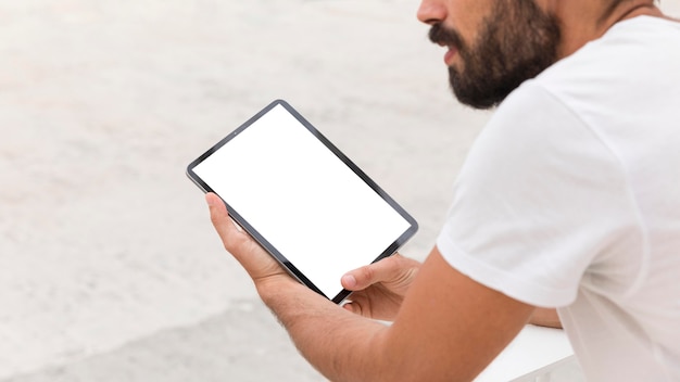 Hombre en la calle con tableta leyendo en línea