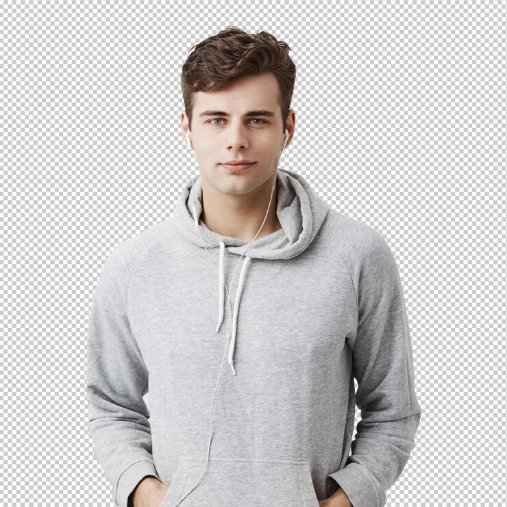 PSD hombre europeo atractivo y guapo con capucha gris con las manos en los bolsillos parece satisfecho tiene buen humor cuando llega a casa después del trabajo estudiante masculino guapo posa