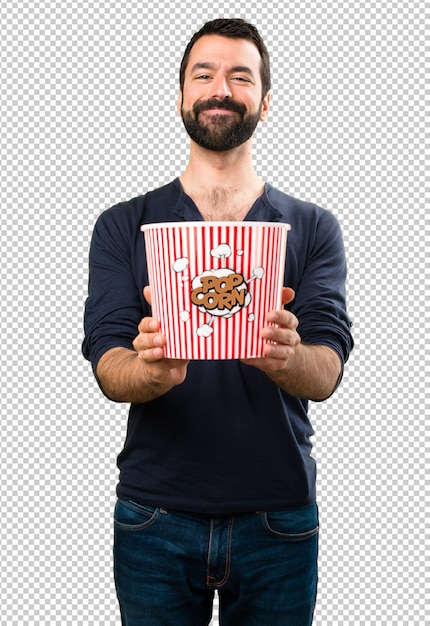 Hombre guapo con barba comiendo palomitas de maíz