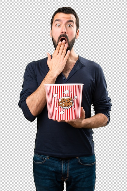 Hombre guapo con barba comiendo palomitas de maíz