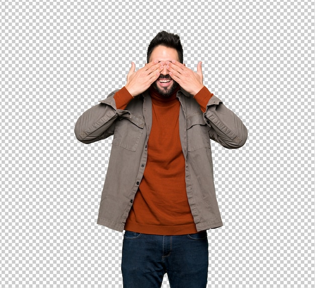 Hombre guapo con barba cubriendo los ojos con las manos. Sorprendido de ver lo que está por delante.