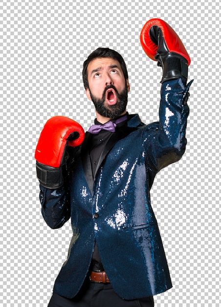 Hombre guapo con chaqueta de lentejuelas con guantes de boxeo