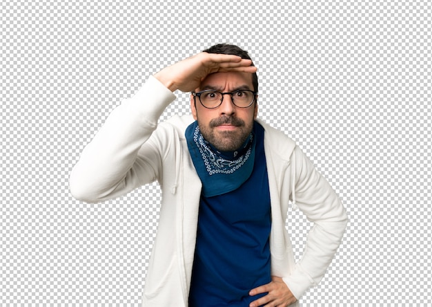 PSD hombre guapo con gafas mirando de lejos con la mano para mirar algo