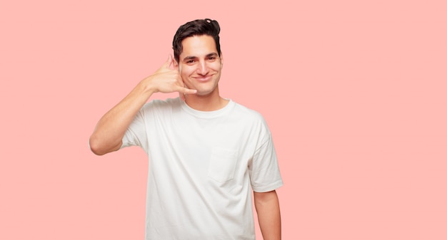 hombre guapo joven haciendo un gesto de llamada de teléfono o signo, con un aspecto orgulloso, feliz y satisfecho