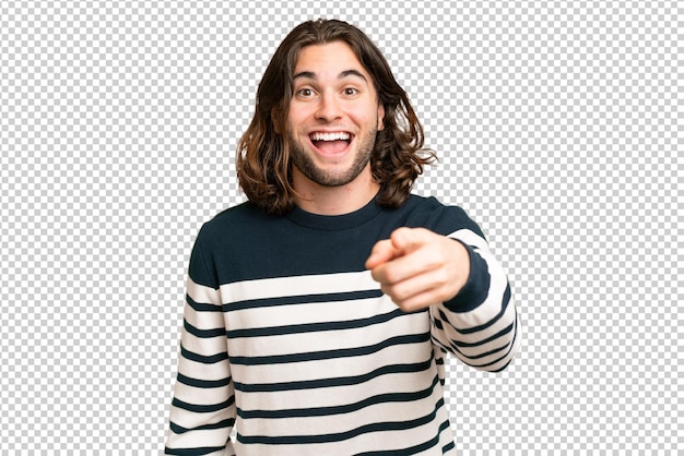 Hombre guapo joven sobre fondo aislado sorprendido y apuntando al frente
