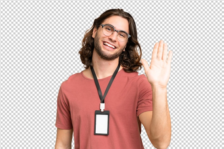 PSD hombre guapo joven con tarjeta de identificación sobre fondo aislado saludando con la mano con expresión feliz