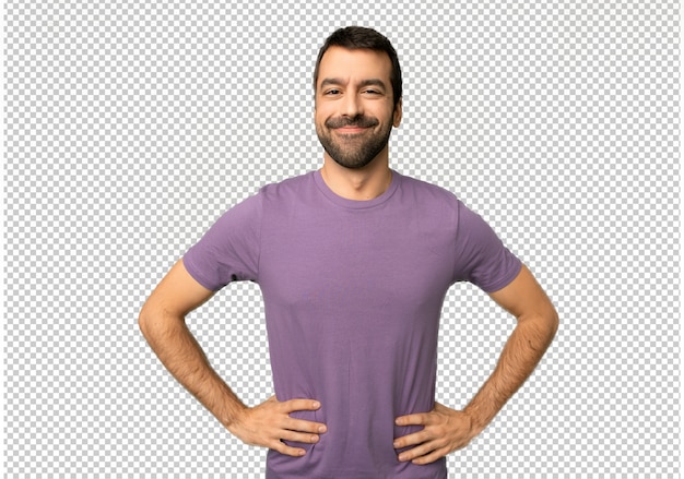 Hombre guapo posando con los brazos en la cadera y riendo mirando hacia el frente