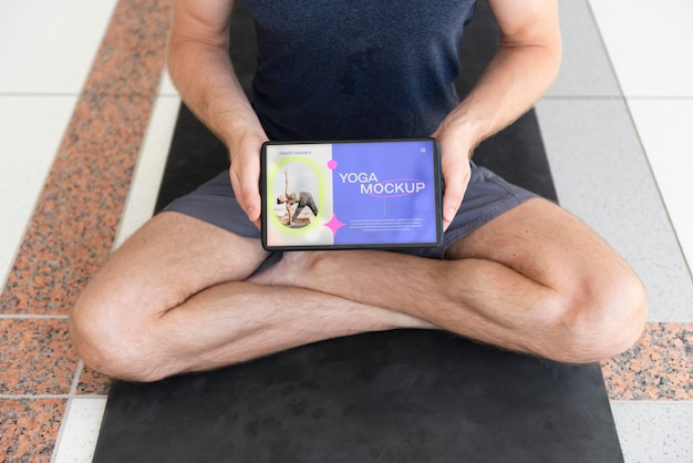 PSD hombre haciendo yoga con diseño de maqueta de computadora portátil