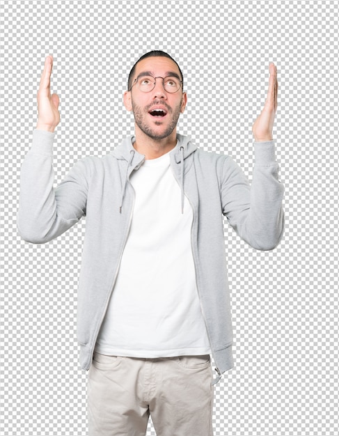 Hombre joven asombrado mirando hacia arriba