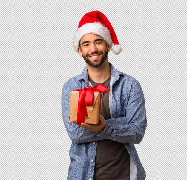 Hombre joven con los brazos de santa cruzando los brazos, sonriendo y relajado