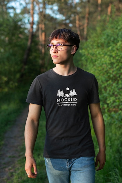 Hombre joven con una camiseta de maqueta en la naturaleza