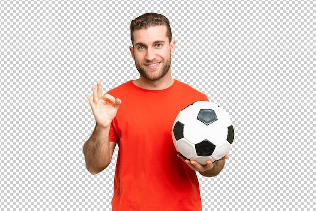 Hombre joven y guapo jugador de fútbol sobre un fondo aislado de llave cromada que muestra el signo ok con los dedos