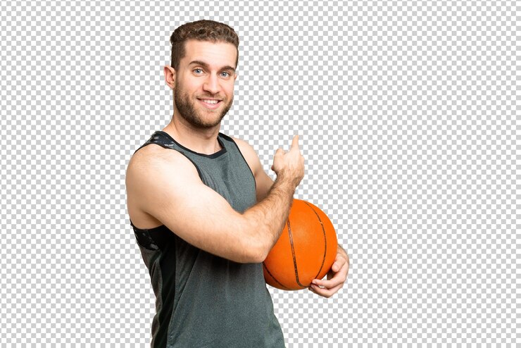 PSD hombre joven guapo jugando al baloncesto sobre el fondo de la llave de croma aislada apuntando hacia atrás