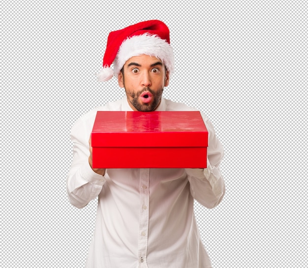 Hombre joven que lleva un sombrero de papá noel el día de navidad