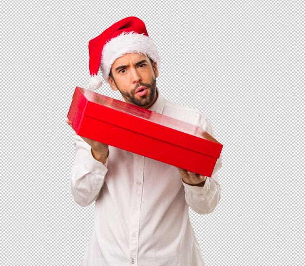 Hombre joven que lleva un sombrero de papá noel el día de navidad