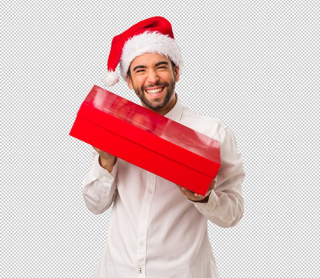 Hombre joven que lleva un sombrero de papá noel el día de navidad