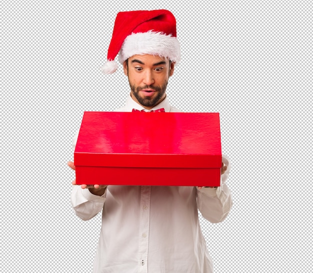 Hombre joven que lleva un sombrero de papá noel el día de navidad