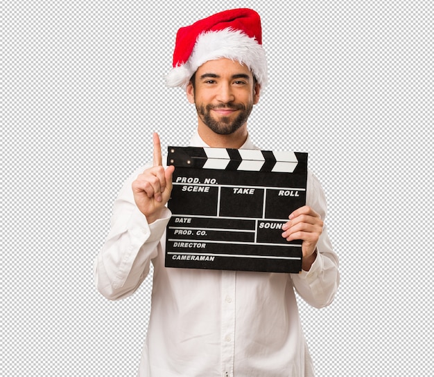 Hombre joven que lleva un sombrero de papá noel el día de navidad