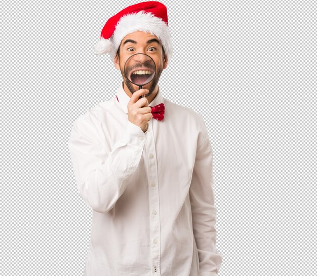 Hombre joven que lleva un sombrero de papá noel el día de navidad