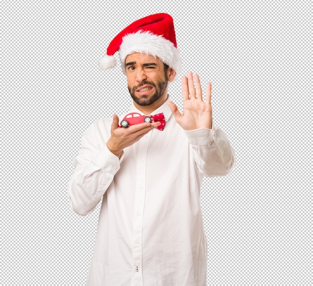 Hombre joven que lleva un sombrero de Papá Noel el día de Navidad