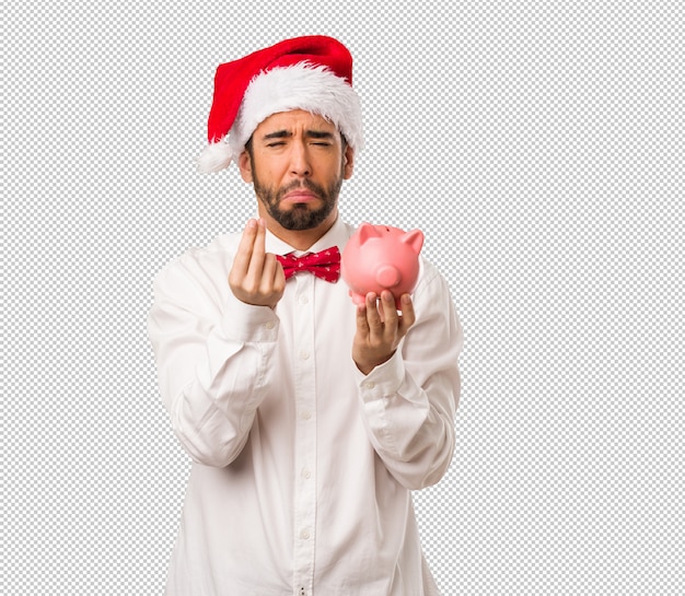 Hombre joven que lleva un sombrero de Papá Noel el día de Navidad