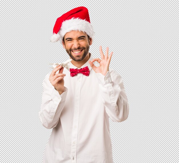 Hombre joven que lleva un sombrero de Papá Noel el día de Navidad