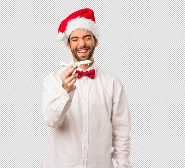 Hombre joven que lleva un sombrero de Papá Noel el día de Navidad