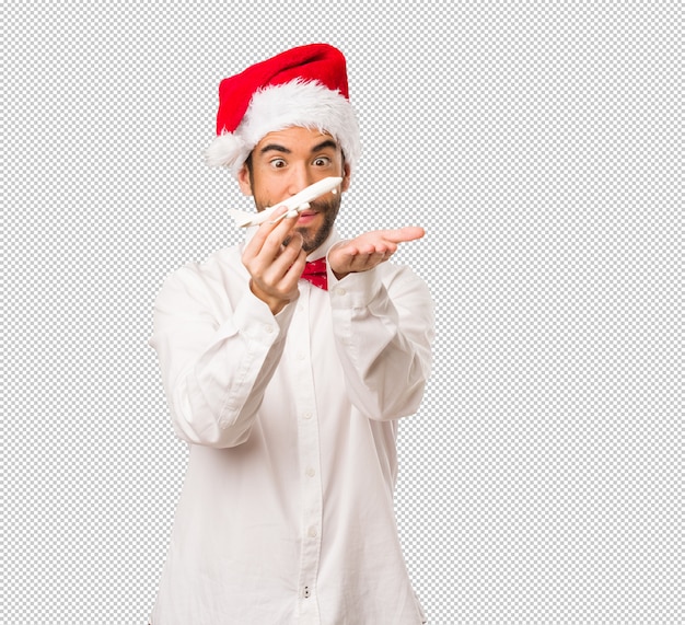 Hombre joven que lleva un sombrero de papá noel el día de navidad