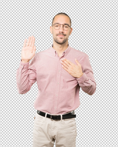 Hombre joven serio con un gesto de juramento