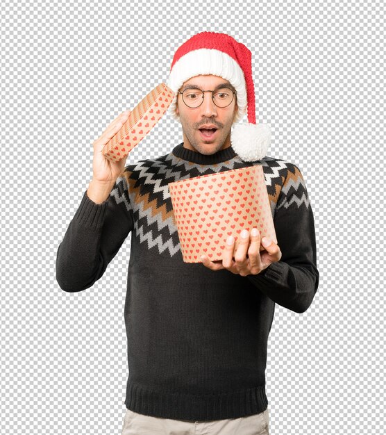 Hombre joven con un sombrero de Navidad mientras gesticula aislado