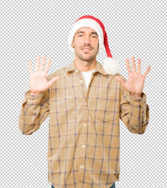 Hombre joven con un sombrero de Navidad mientras gesticula aislado