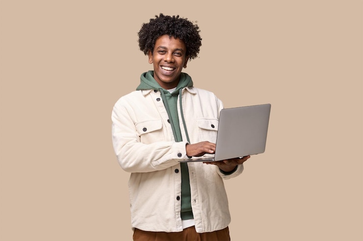 Hombre joven sonriente que usa la computadora portátil