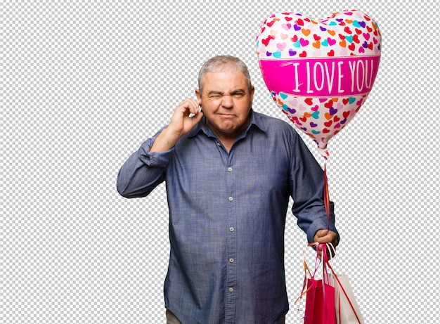 Hombre de mediana edad celebrando el día de San Valentín cubriendo las orejas con las manos