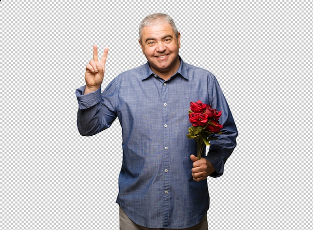 Hombre de mediana edad celebrando el día de san valentín divertido y feliz haciendo un gesto de victoria