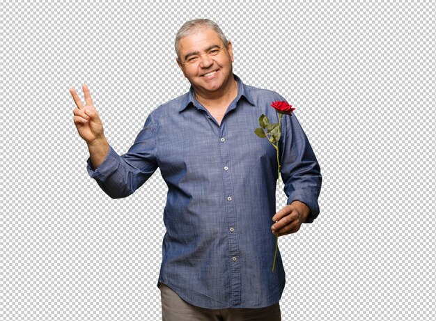 Hombre de mediana edad celebrando el día de San Valentín haciendo un gesto de victoria