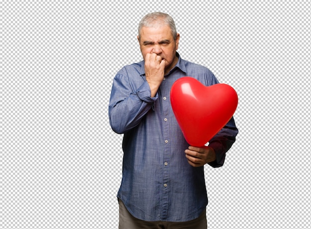 PSD hombre de mediana edad celebrando el día de san valentín mordiéndose las uñas, nervioso y muy ansioso.